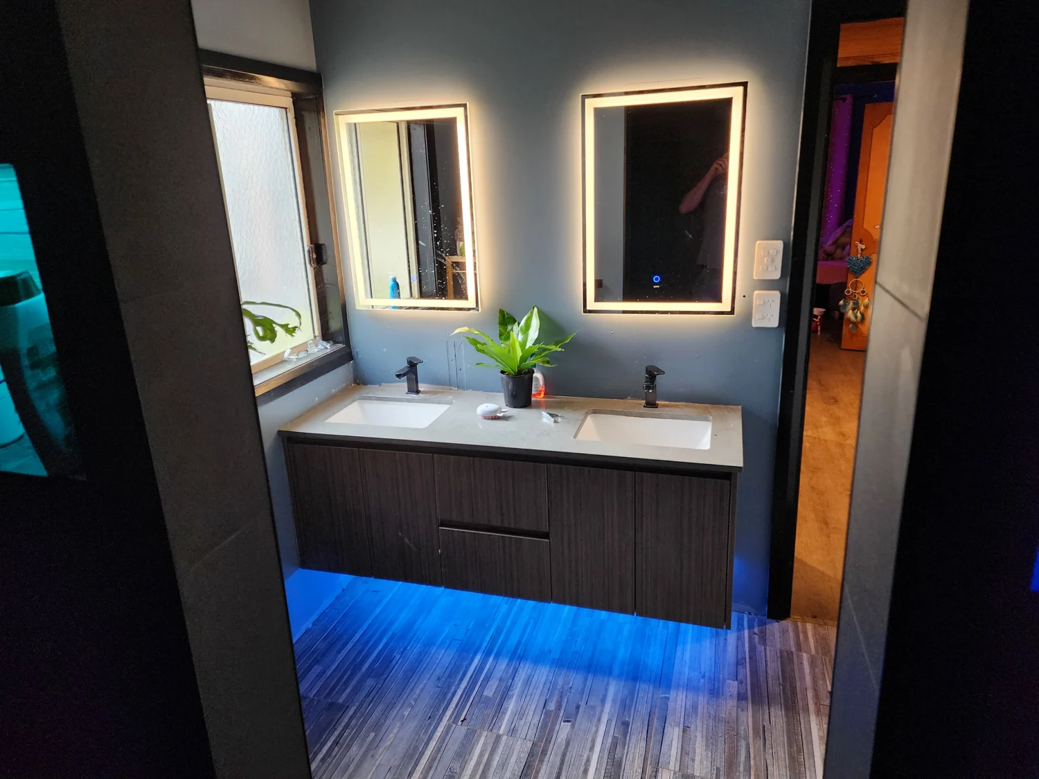 Bathroom with illuminated mirrors and blue under-vanity lighting